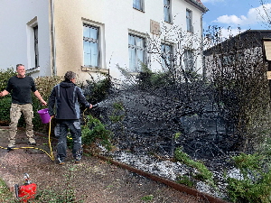 Anwohner lschen Feuer vor der alten Schule